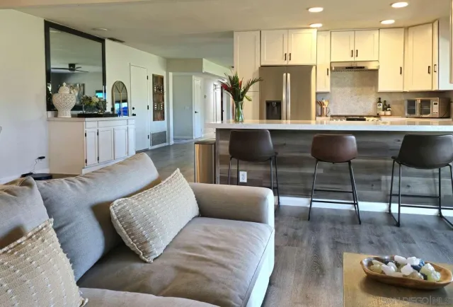 a living room with stainless steel appliances furniture a kitchen view and a kitchen view