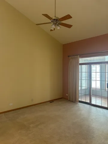 an empty room with a ceiling fan and a window