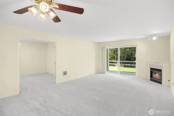 a view of an empty room with a fireplace and a window