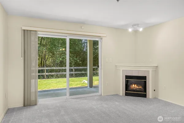 an empty room with floor to ceiling windows and a fireplace