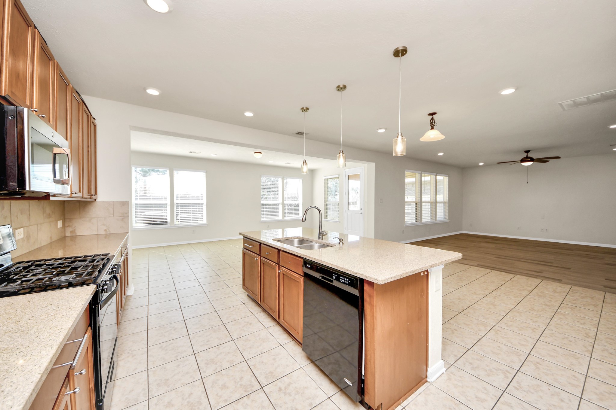 24123 Adobe Ridge Lane Katy, TX 77493 - Photo 24 of 45 a large kitchen with stainless steel appliances granite countertop a large counter top a stove a sink a chimney and a refrigerator