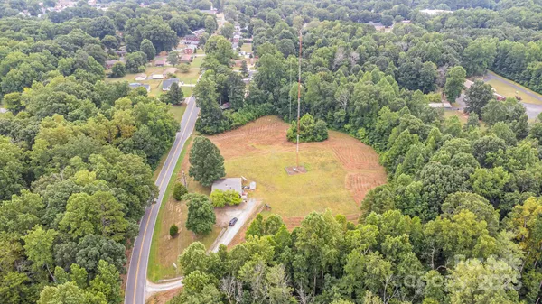 an aerial view of a residential houses with yard and green space