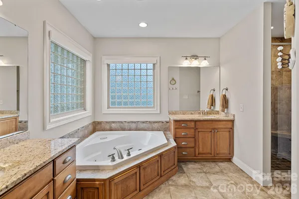 a spacious bathroom with a granite countertop tub sink and mirror