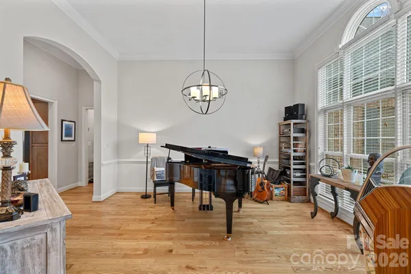 a living room with furniture a piano and a flat screen tv