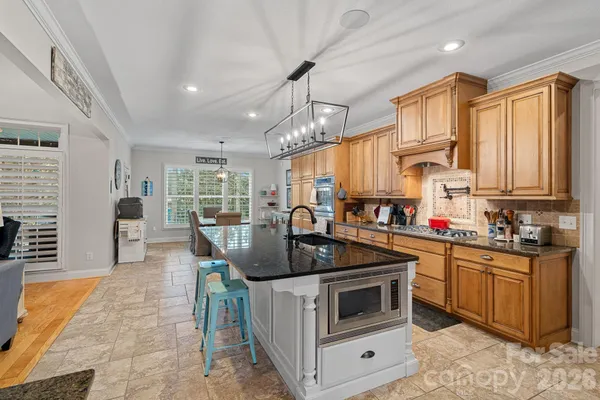 a kitchen with stainless steel appliances granite countertop a stove a sink and a refrigerator