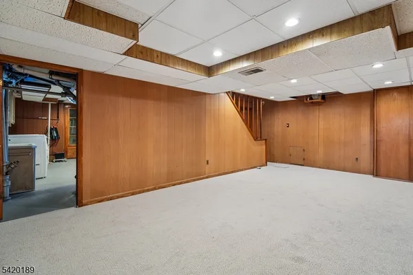a view of a house with a big yard and large tree