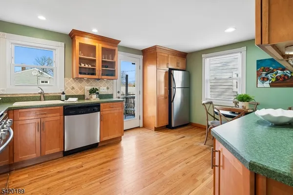 a kitchen with stainless steel appliances granite countertop wooden cabinets a stove a sink and a microwave