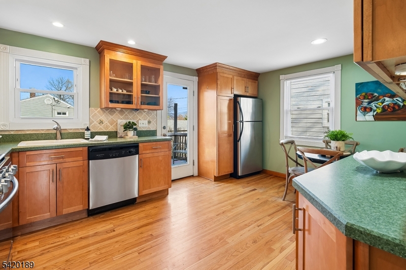 8 Edison Drive Summit, NJ 07901 - Photo 7 of 34 a kitchen with stainless steel appliances granite countertop a refrigerator a sink dishwasher and wooden cabinets with wooden floor