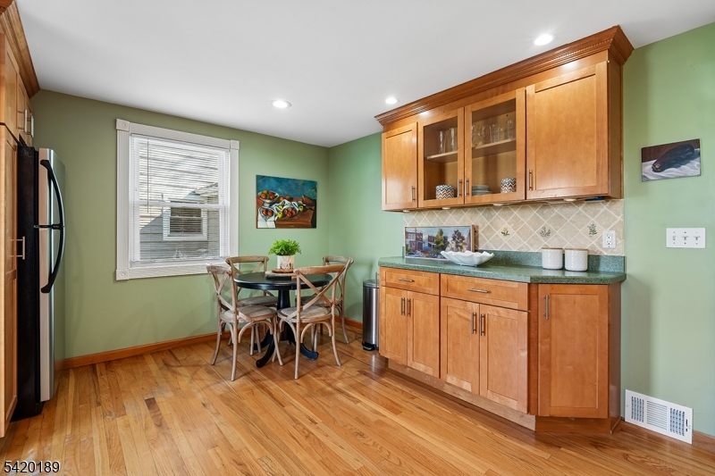 8 Edison Drive Summit, NJ 07901 - Photo 10 of 34 a kitchen with stainless steel appliances granite countertop wooden cabinets a dining table and chairs