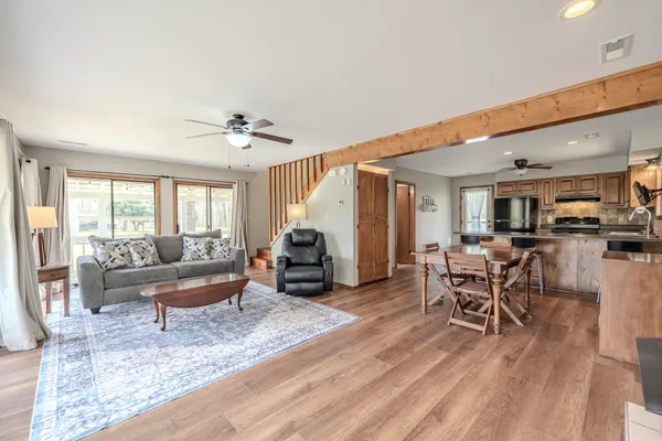 a living room with furniture a table and wooden floor