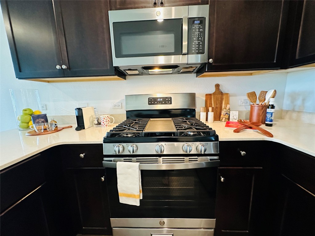 13410 Mussel Run Elgin, TX 78621 - Photo 3 of 32 a kitchen with stainless steel appliances granite countertop a stove and a microwave