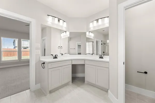 a large white bathroom with a double vanity sink and a mirror