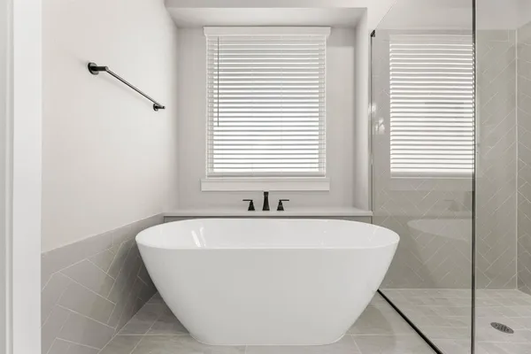 a white bath tub sitting in a bathroom next to a window
