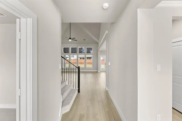 a view of a hallway with wooden floor and staircase