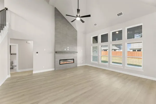 a view of empty room with a fireplace and wooden floor