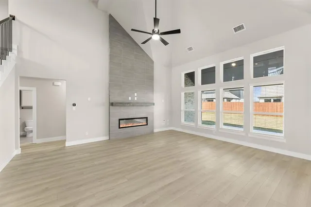 a view of empty room with a fireplace and wooden floor