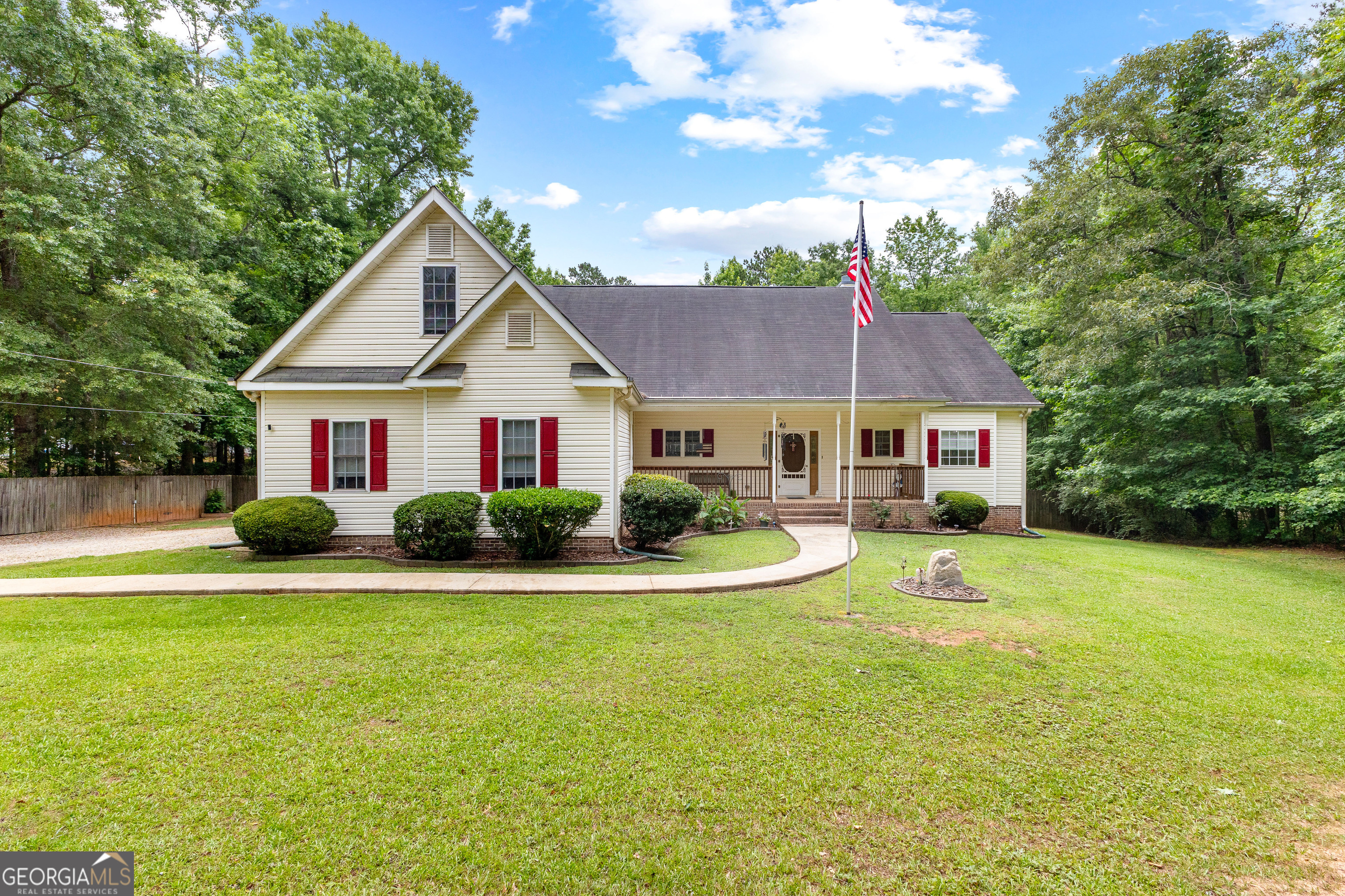a front view of a house with yard and green space