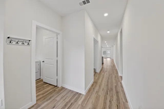 a view of a hallway with wooden floor and staircase
