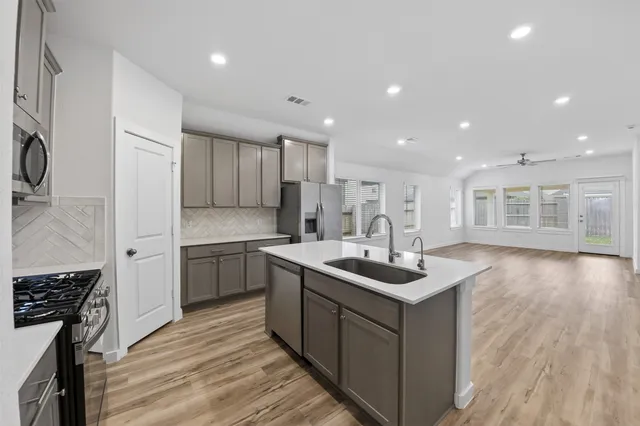 a kitchen with a sink stove and wooden cabinets