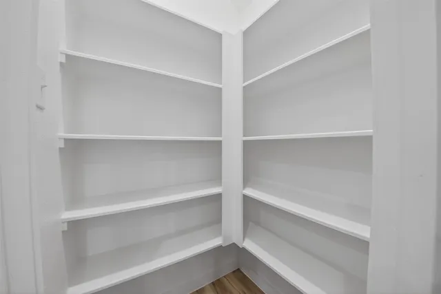 a view of walk in closet with empty racks