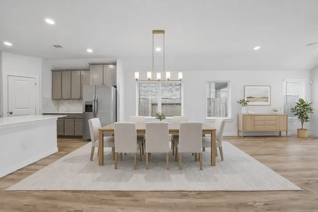 a dining room with wooden floor a chandelier a wooden table and chairs