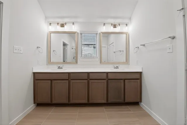 a bathroom with a double vanity sink mirror and