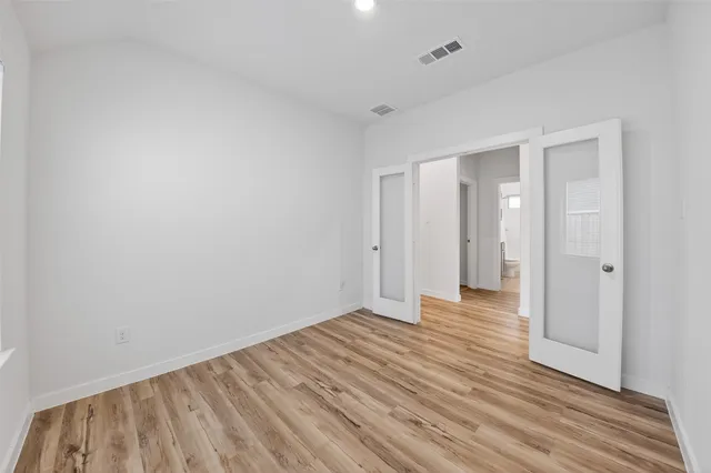 a view of an empty room with wooden floor