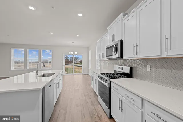 a large kitchen with stainless steel appliances granite countertop a lot of counter space and a sink