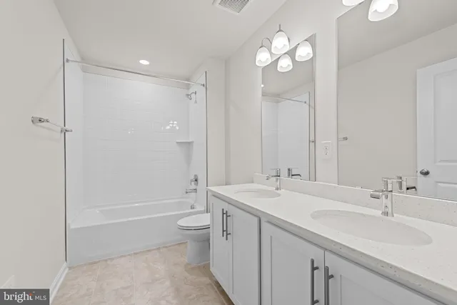 a bathroom with a double vanity sink mirror double and bathtub
