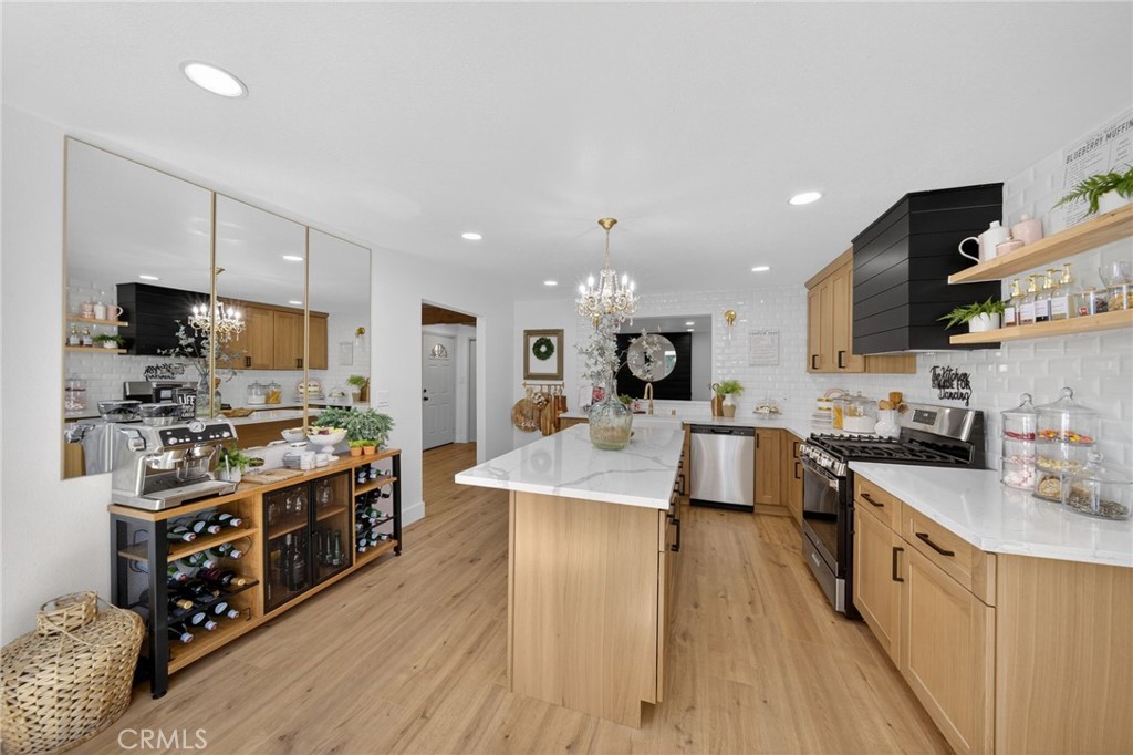 a large kitchen with stainless steel appliances lots of counter space and wooden floor