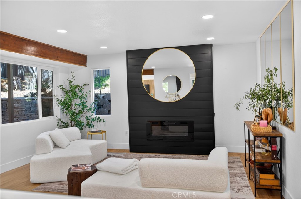 1171 Bear Springs Road Rimforest, CA 92378 - Photo 41 of 43 a living room with furniture a mirror and a fireplace