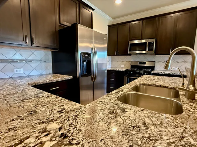 a kitchen with stainless steel appliances wooden cabinets a refrigerator and a sink