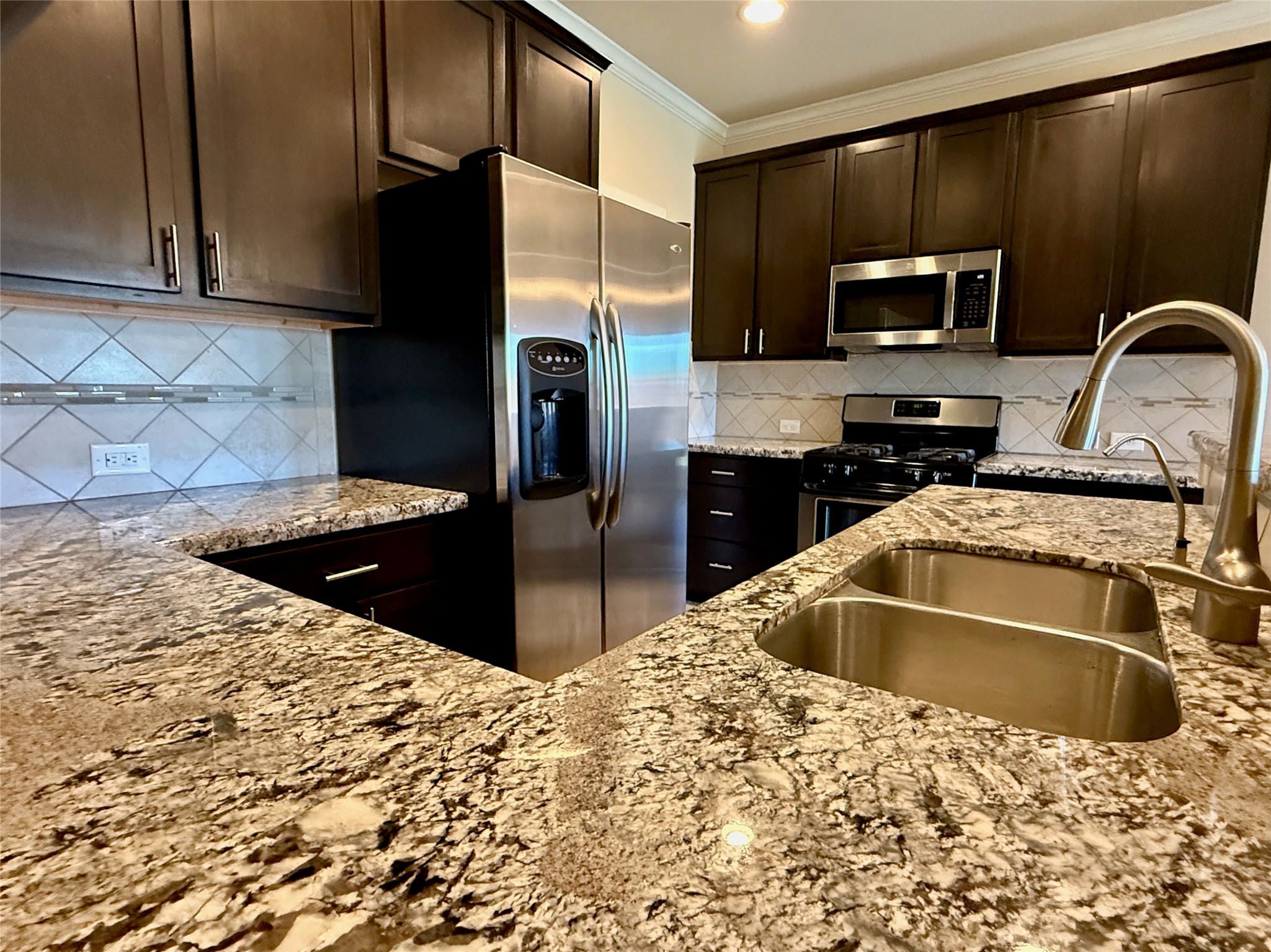 1842 Jara Court Spring, TX 77388 - Photo 20 of 31 a kitchen with stainless steel appliances wooden cabinets a refrigerator and a sink