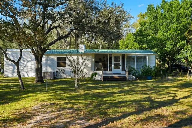 a view of a house with backyard and sitting area
