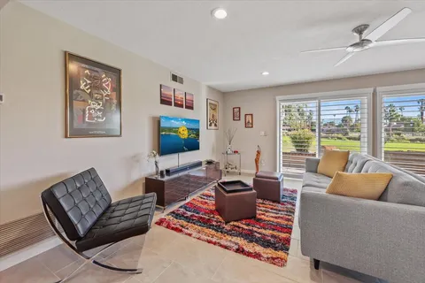 a living room with furniture a rug and a large window