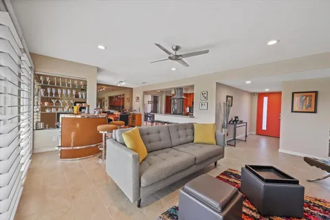 a living room with furniture and a view of kitchen