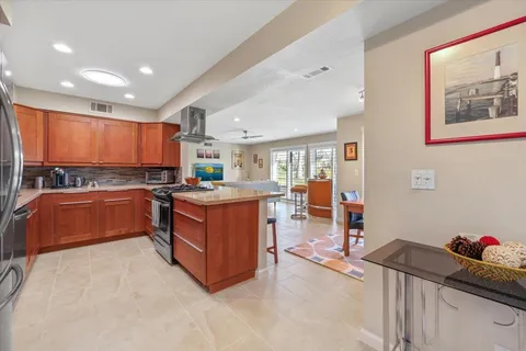 a kitchen with stainless steel appliances kitchen island granite countertop a stove and cabinets