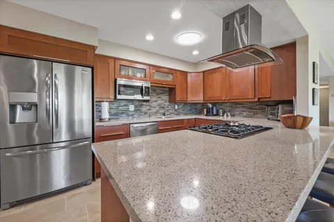 a kitchen with stainless steel appliances granite countertop a sink stove and refrigerator