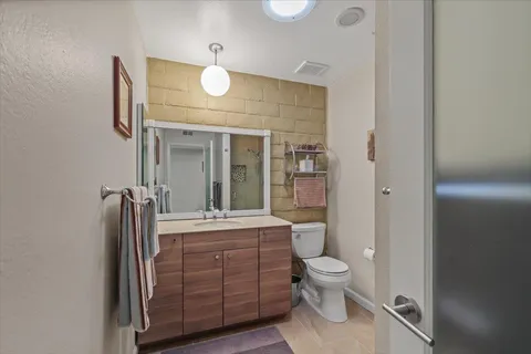 a bathroom with a toilet a sink and mirror