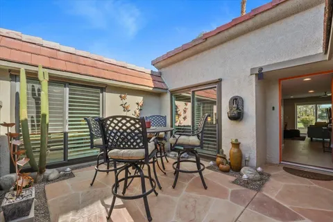 a view of a patio with a table and chairs and potted plants