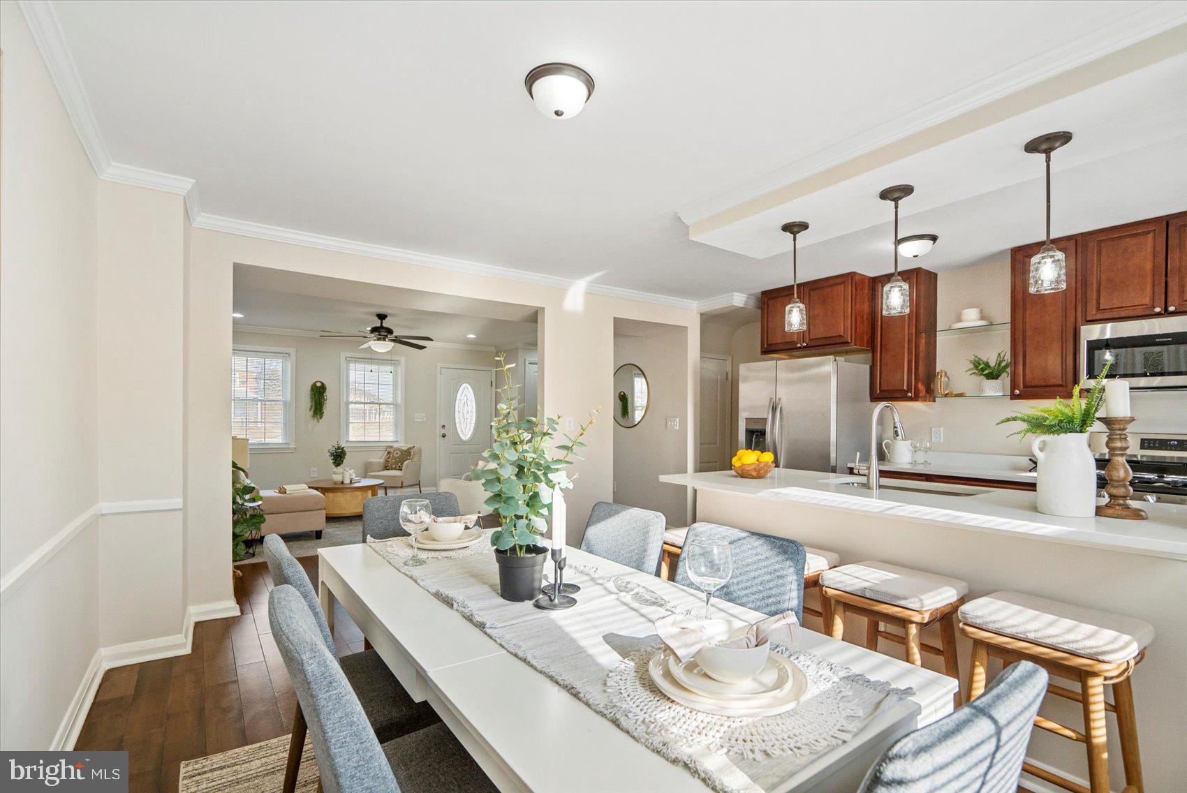 1283 Cedarcroft Road Baltimore, MD 21239 - Photo 11 of 39 a view of a dining room and livingroom with furniture wooden floor a chandelier