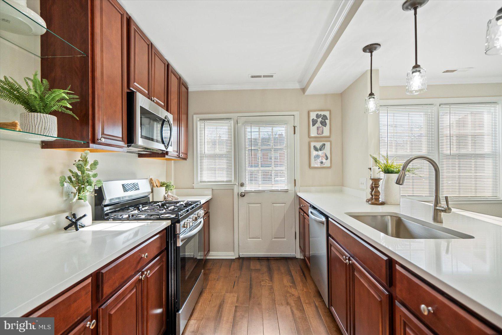 1283 Cedarcroft Road Baltimore, MD 21239 - Photo 14 of 39 a kitchen with a sink stove and cabinets