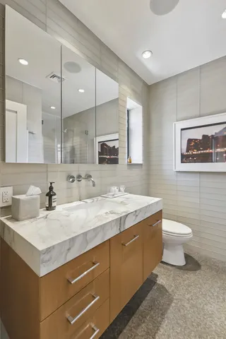 a bathroom with a sink a toilet and a mirror