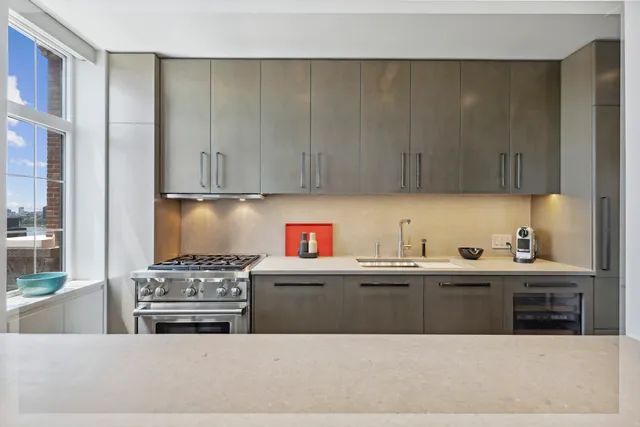 a kitchen with stainless steel appliances a sink a stove a refrigerator and cabinets