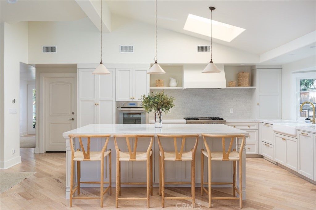 1941 Commodore Road Newport Beach, CA 92660 - Photo 7 of 35 a kitchen with stainless steel appliances kitchen island granite countertop a table chairs stove and refrigerator