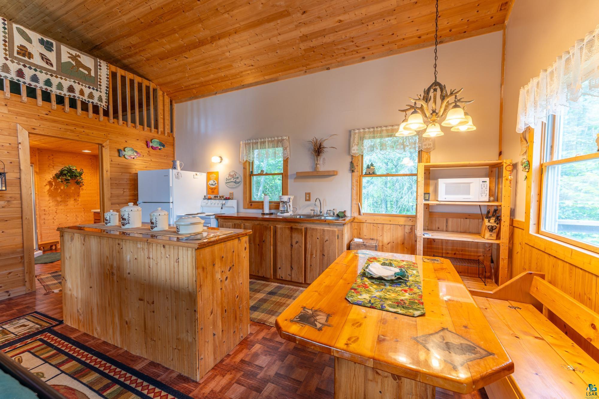 296 Shady Lane Ely, MN 55731 - Photo 7 of 27 Kitchen featuring white appliances, wood ceiling, wood walls, and parquet flooring
