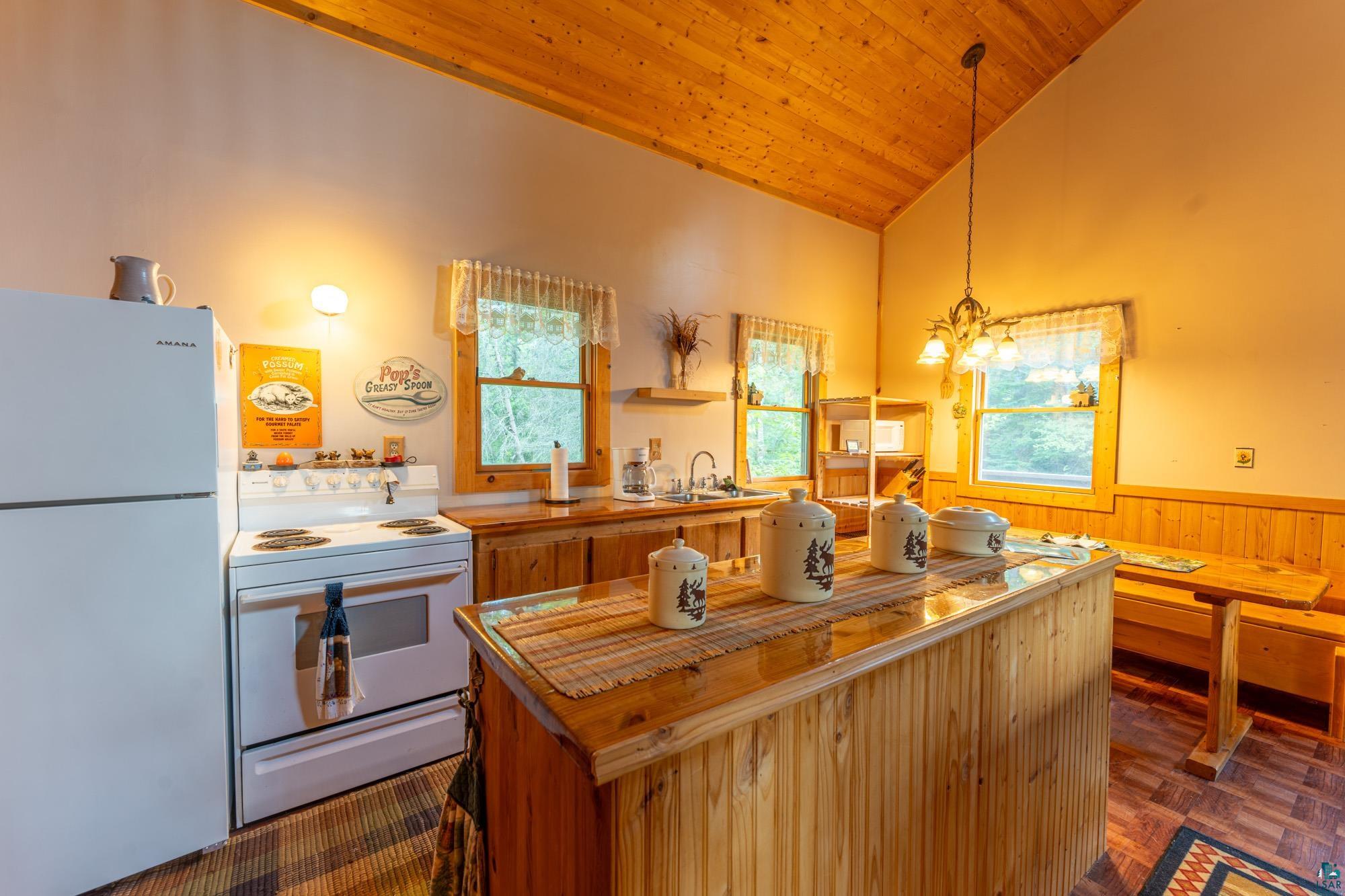 296 Shady Lane Ely, MN 55731 - Photo 8 of 27 Kitchen featuring white appliances, wooden ceiling, pendant lighting, vaulted ceiling, and butcher block countertops