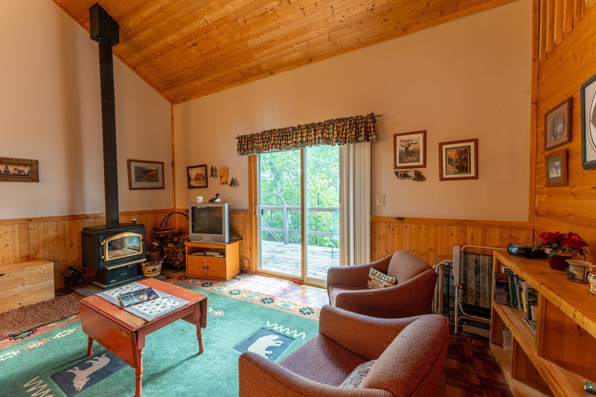 296 Shady Lane Ely, MN 55731 - Photo 10 of 27 Living room featuring wood ceiling, high vaulted ceiling, parquet floors, and a wood stove