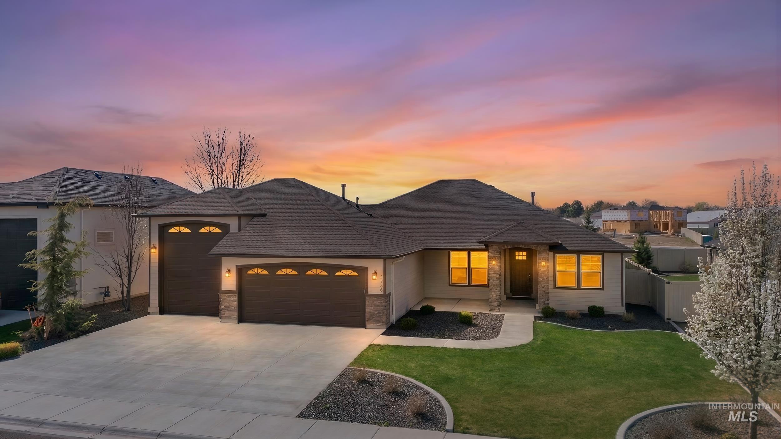 4518 Gap Creek Avenue Caldwell, ID 83607 - Photo 1 of 1 French country home with a garage, driveway, a front yard, a shingled roof, and stone siding