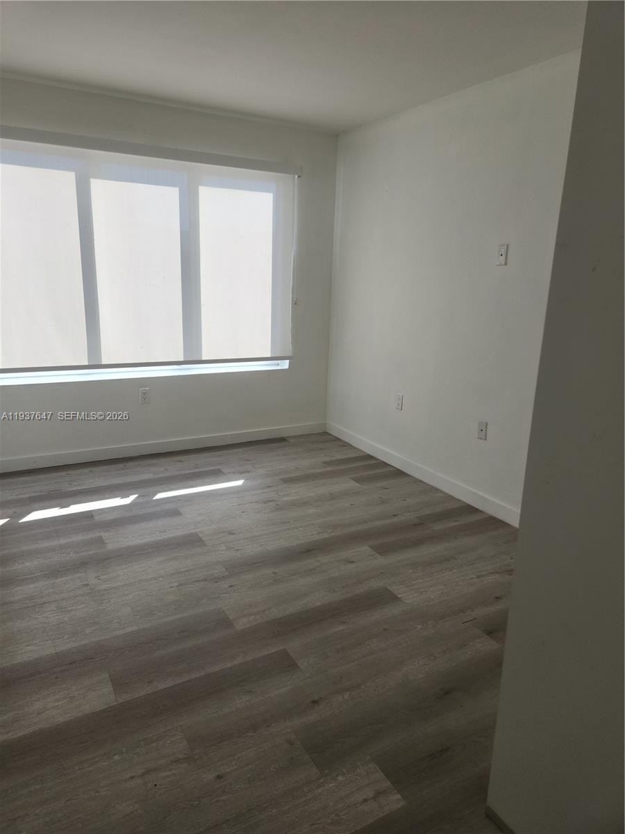 13937 Southwest 259th Street Homestead, FL 33032 - Photo 7 of 17 wooden floor in an empty room with a window